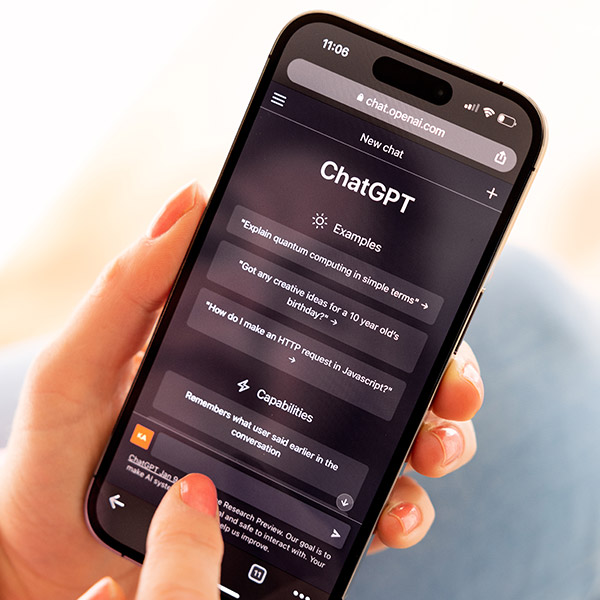 woman's hand holding a smartphone using ChatGPT interface